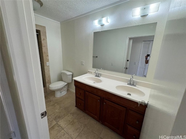 bathroom with vanity, a textured ceiling, and toilet