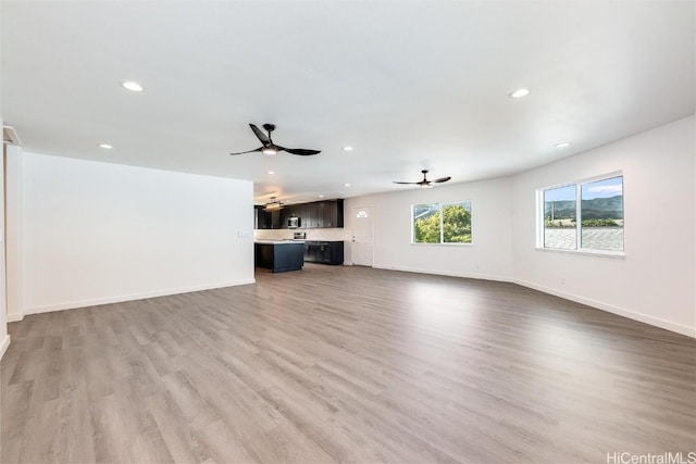 unfurnished living room with ceiling fan and light wood-type flooring