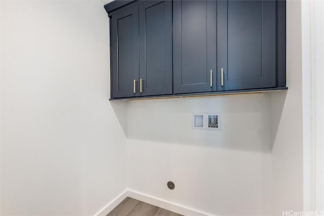 clothes washing area featuring washer hookup, wood-type flooring, and cabinets