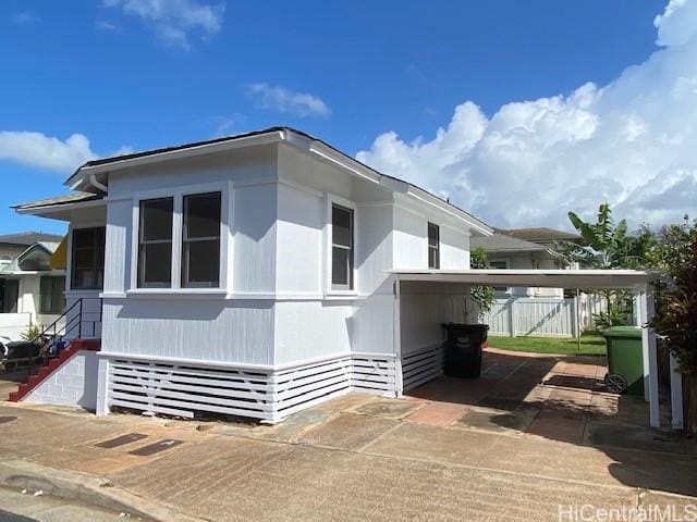 view of side of home with a carport and driveway