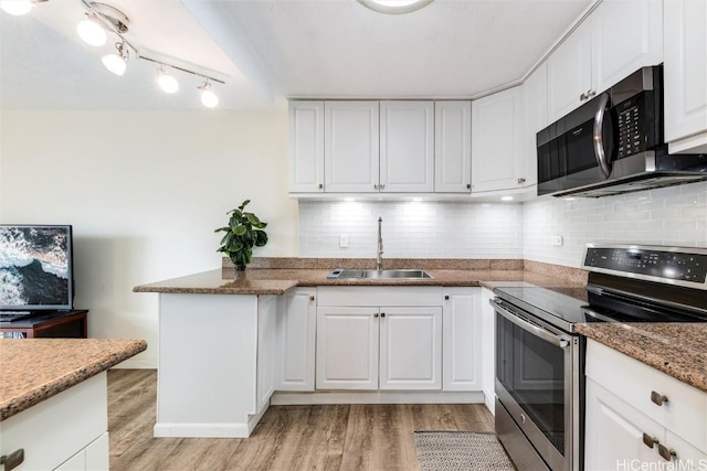 kitchen with white cabinetry, sink, light hardwood / wood-style flooring, and appliances with stainless steel finishes