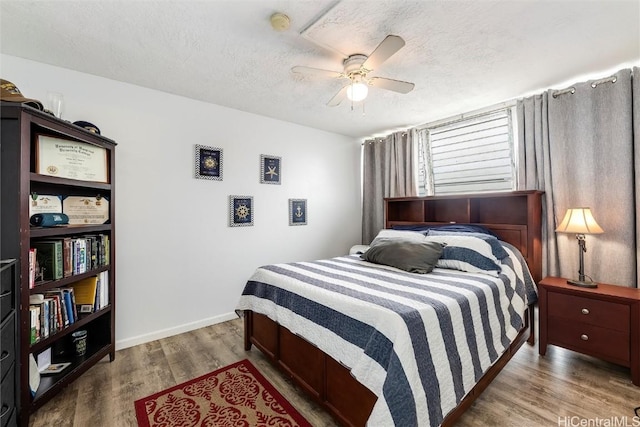 bedroom featuring hardwood / wood-style flooring, ceiling fan, and a textured ceiling