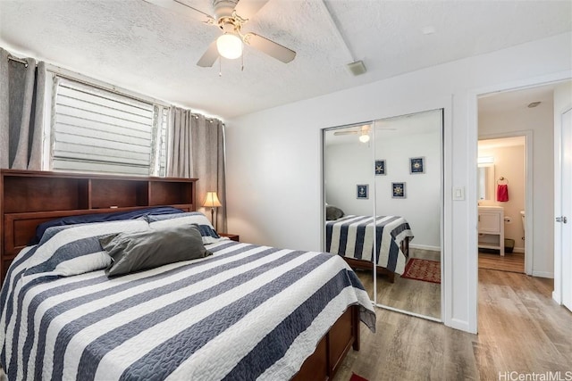 bedroom with ceiling fan, a closet, light hardwood / wood-style flooring, and a textured ceiling