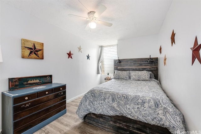 bedroom with a textured ceiling, light hardwood / wood-style flooring, and ceiling fan