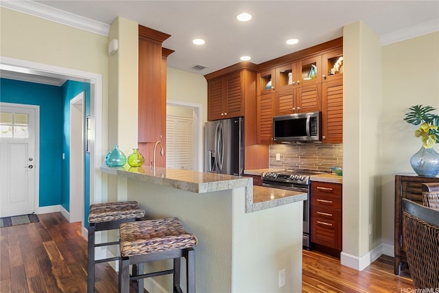 92-1110 Olani St Unit 20-6, Kapolei, HI 96707 - kitchen featuring stainless steel appliances, dark wood-style floors, visible vents, a kitchen bar, and decorative backsplash