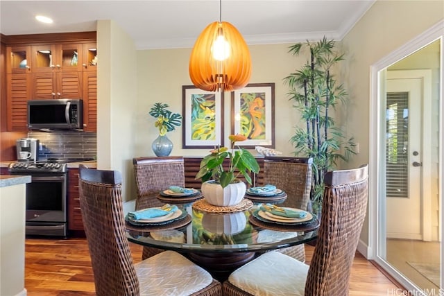 dining area with crown molding and light hardwood / wood-style floors