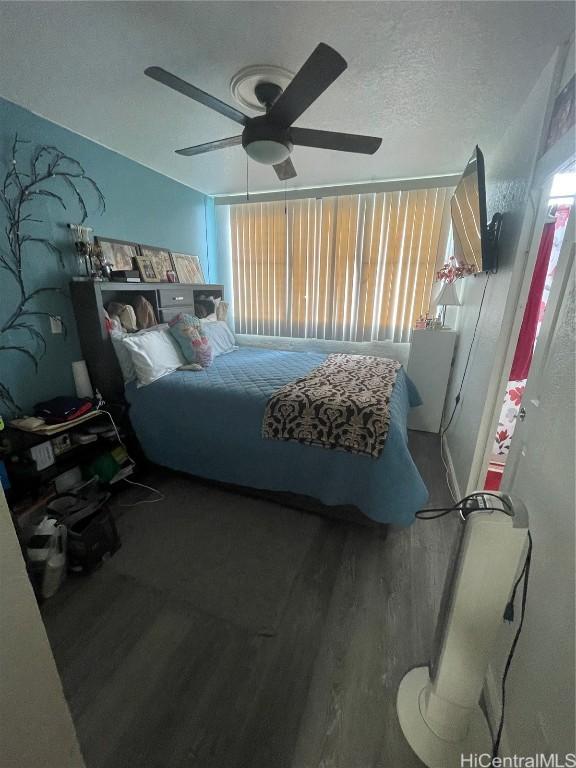 bedroom with multiple windows, hardwood / wood-style flooring, a textured ceiling, and ceiling fan