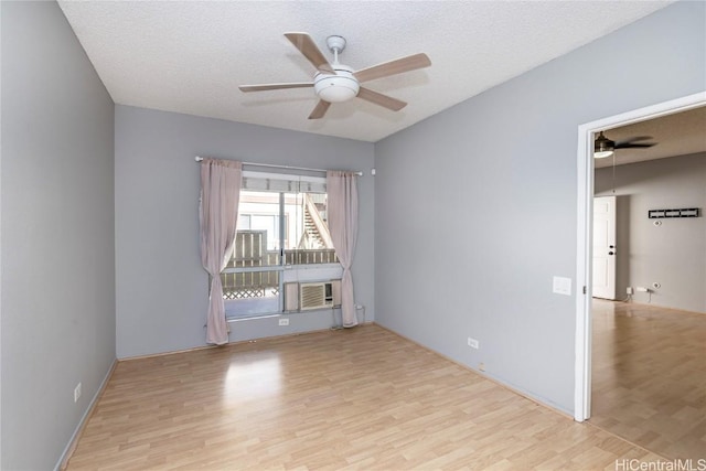 empty room with ceiling fan, light hardwood / wood-style flooring, and a textured ceiling