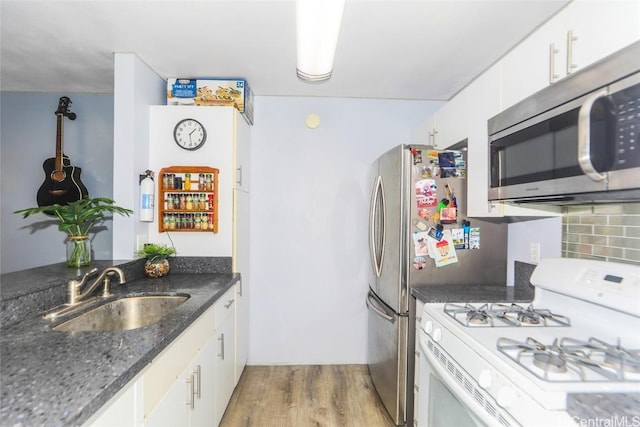 kitchen with sink, white cabinets, light wood-type flooring, and white gas range oven