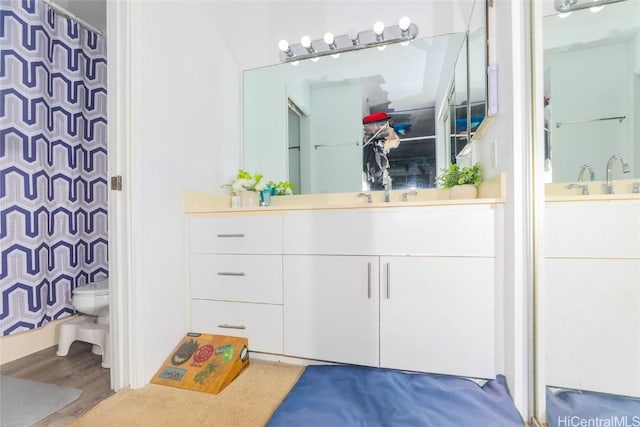 bathroom with vanity, wood-type flooring, and toilet