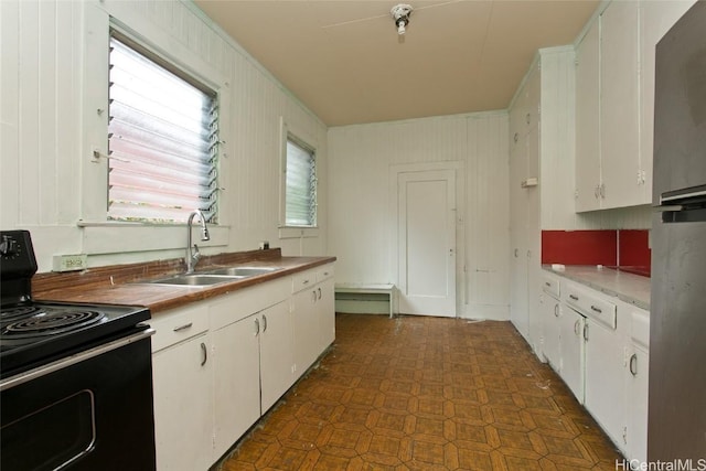 kitchen featuring white cabinets, sink, and electric range