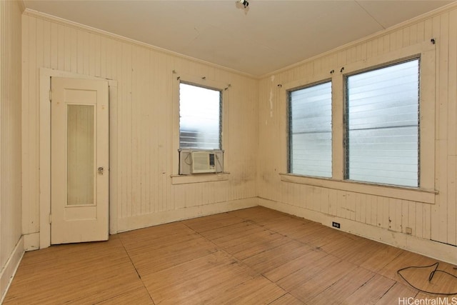 spare room featuring cooling unit, hardwood / wood-style floors, and crown molding