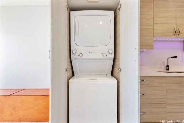 washroom featuring stacked washer and dryer and sink