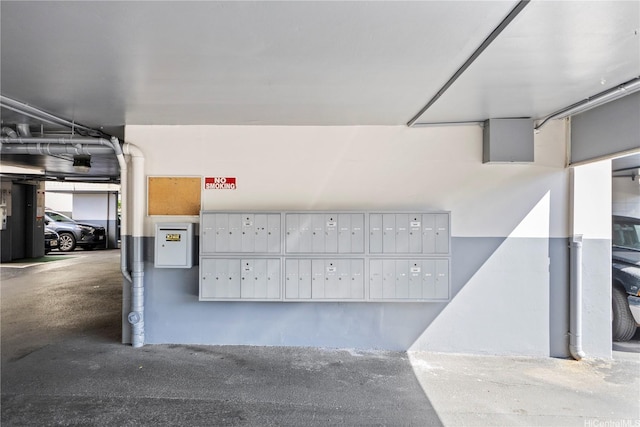 view of property's community with mail area and a parking garage