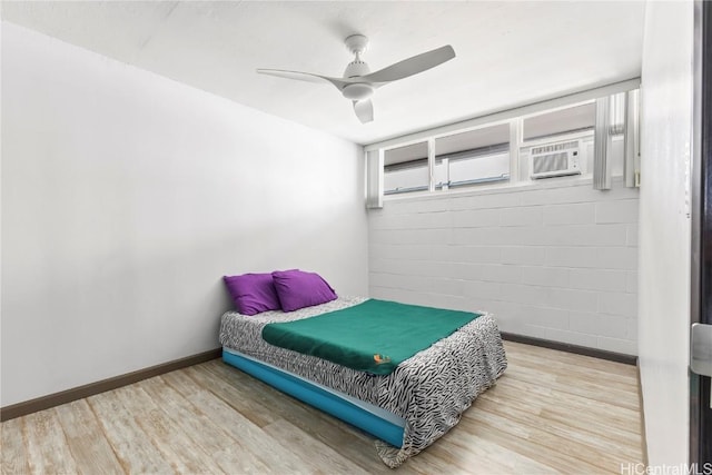 bedroom featuring ceiling fan, cooling unit, and light hardwood / wood-style floors