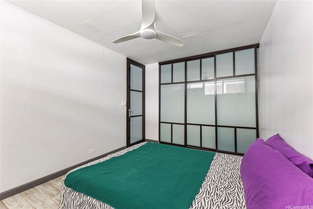 bedroom with wood finished floors, ceiling fan, and baseboards