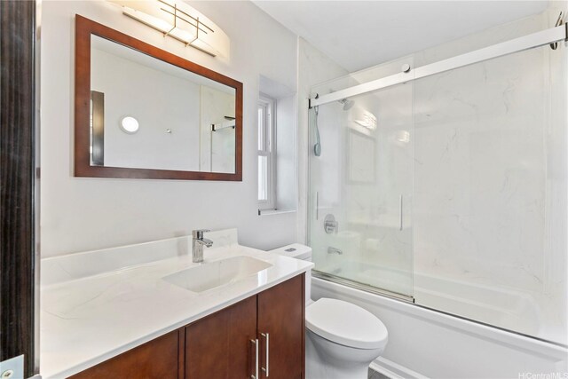 full bath with vanity, bath / shower combo with glass door, and toilet