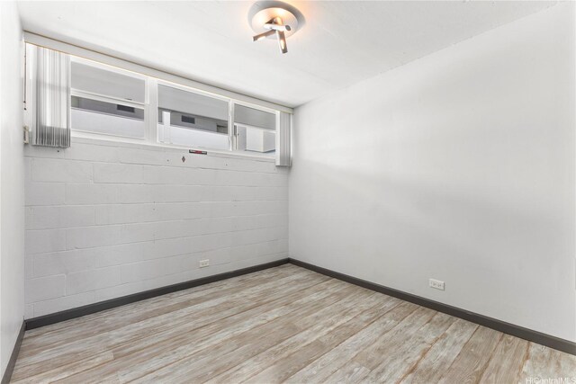empty room with baseboards and wood finished floors