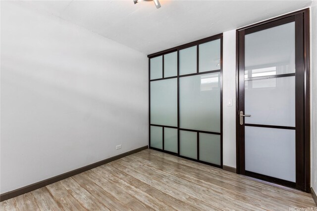 unfurnished bedroom with wood finished floors and baseboards