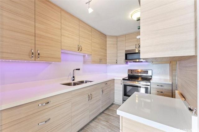 kitchen with stainless steel appliances, light brown cabinets, and sink