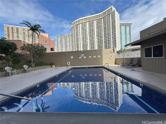 community pool featuring a view of city and a patio area