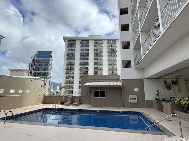 view of swimming pool featuring a view of city and a patio