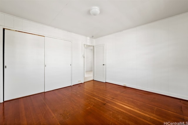 unfurnished bedroom featuring hardwood / wood-style floors and a closet