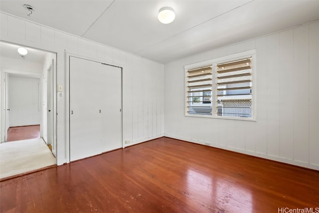 unfurnished bedroom with hardwood / wood-style flooring and a closet