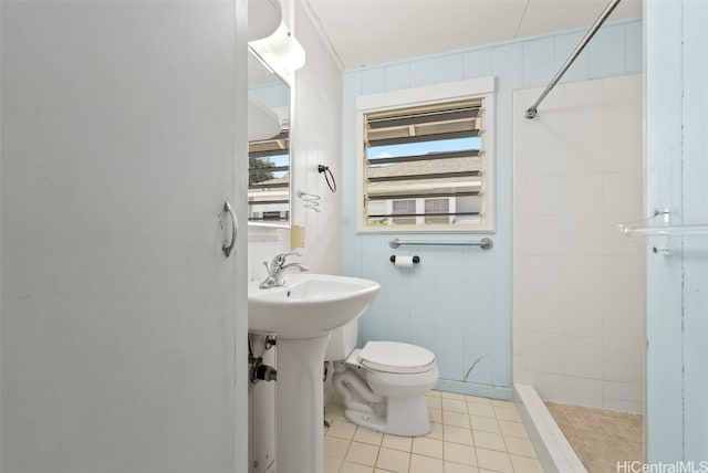 bathroom with tiled shower, tile patterned floors, toilet, sink, and radiator