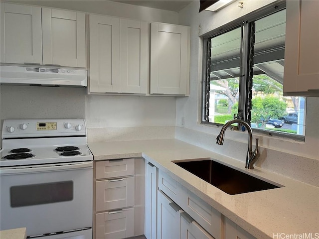 kitchen with sink, light stone counters, white cabinets, and white range with electric stovetop