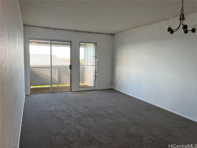 empty room with a chandelier and dark carpet