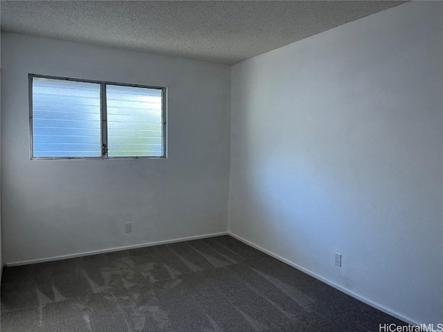 carpeted empty room featuring a textured ceiling