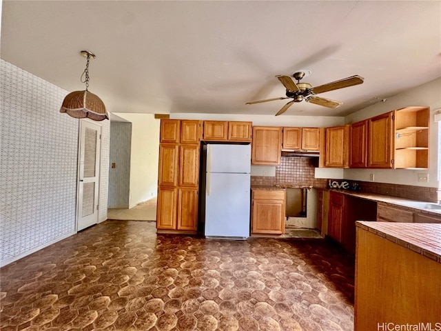 kitchen with ceiling fan, decorative light fixtures, and white fridge