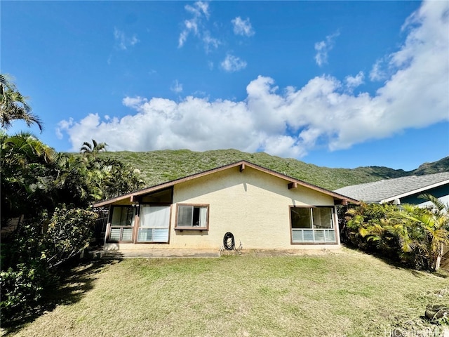 back of house featuring a yard and a mountain view