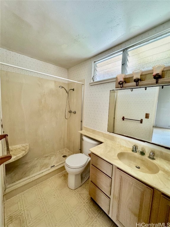 bathroom with a shower, vanity, a textured ceiling, and toilet