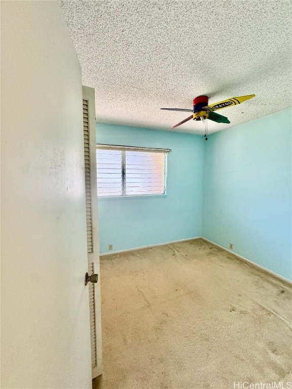 unfurnished room with ceiling fan, carpet floors, and a textured ceiling