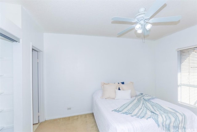 bedroom with ceiling fan and light carpet