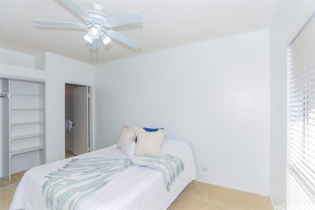 bedroom featuring ceiling fan, light colored carpet, and a closet