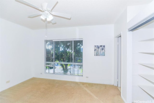 carpeted spare room with ceiling fan