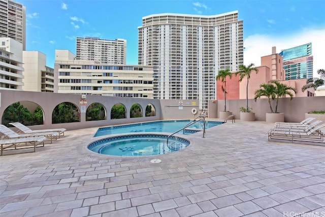 view of swimming pool with a community hot tub and a patio