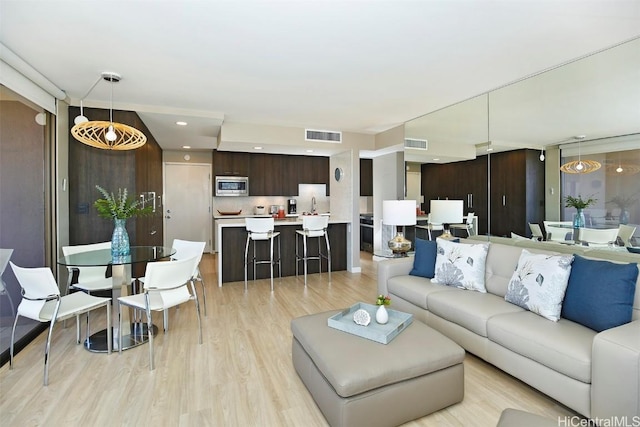 living room featuring sink and light wood-type flooring