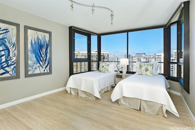 bedroom with track lighting and light hardwood / wood-style floors