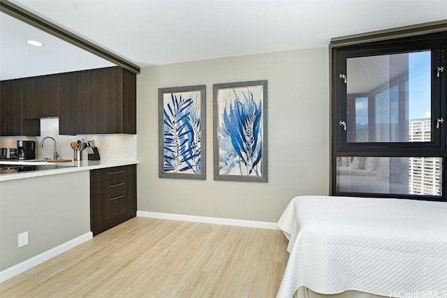 bedroom with sink and light hardwood / wood-style floors