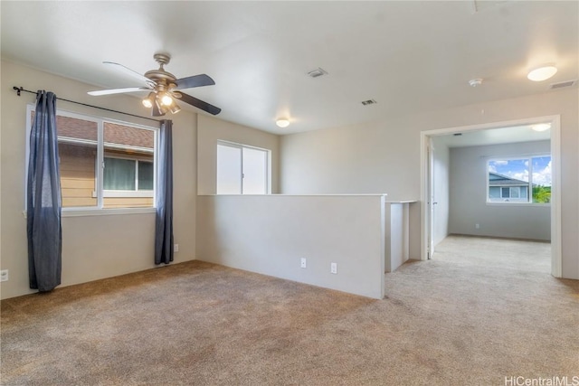 carpeted spare room featuring ceiling fan