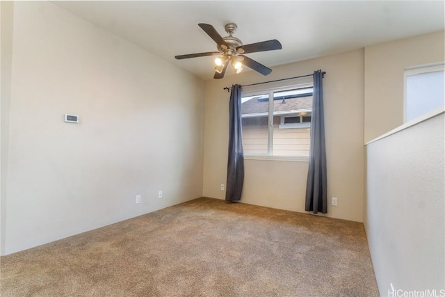 carpeted spare room with ceiling fan