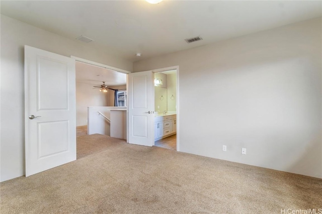 unfurnished bedroom with connected bathroom and light carpet