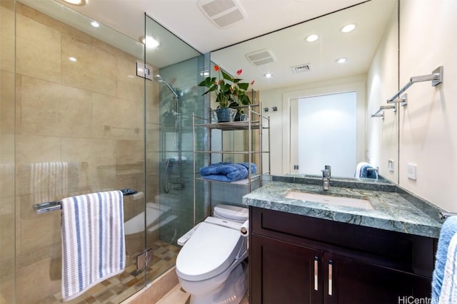 bathroom with vanity, a shower with shower door, and toilet