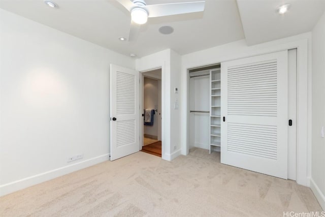 unfurnished bedroom with light carpet, a closet, and ceiling fan