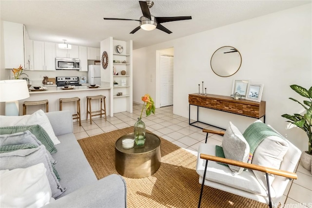 tiled living room with ceiling fan and a textured ceiling