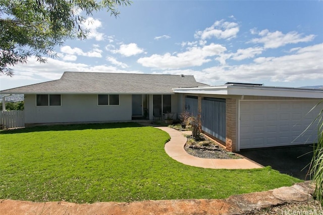 rear view of house with a garage and a yard